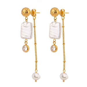 Elegant gold bow earrings with pearls, zircons and long tassels on a white background