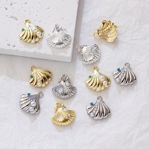 Detailed close-up of mixed alloy shell charms with pearls and blue rhinestones for DIY jewelry