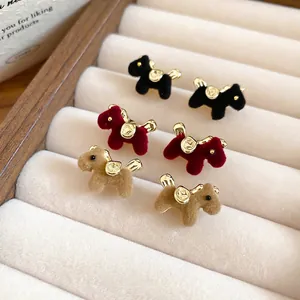 Flocked puppy stud earrings in black, burgundy and camel displayed in a soft jewelry box