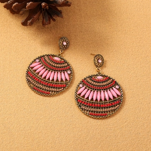 Detailed close-up of bohemian bronze chandelier earrings with pink marquise beads and red gems