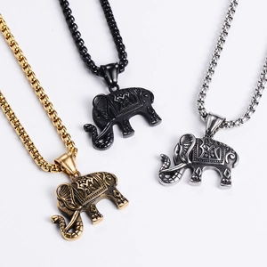 Detailed macro view of African elephant pendants in gold, silver, and black stainless steel