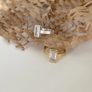Detailed shot of vintage silver and gold rings with rectangular zircon on honeycomb paper