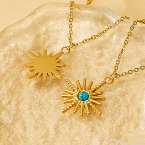 Vintage gold starburst necklaces with turquoise inlay on elegant glass display