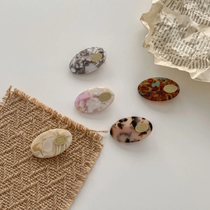 Set of 5 acetate oval hair clips with marble and tortoise shell patterns on a white background