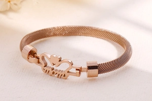 Detail of rose gold mesh bracelet featuring hollow heart and MOM lettering design