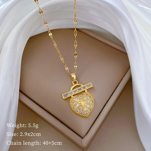 Macro detail of gold heart pendant with cubic zirconia and star engraving on chain