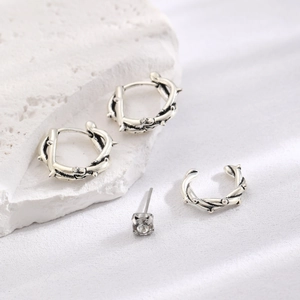 Macro shot of silver gothic ear cuff set with thorn hoop earrings and clear crystal stud