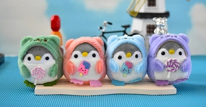 Detailansicht von vier bunten Pinguin-Plüschanhängern mit kleinen Süßigkeiten-Accessoires