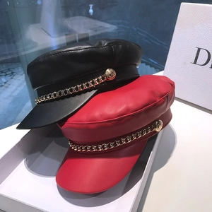 Retro faux leather baker boy caps in black and red with gold chain and button details