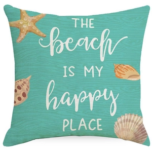 Close-up of teal linen cushion with beach theme typography and shell texture detail