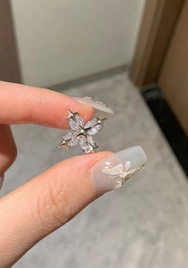 Detailed close-up of a silver cross ear cuff with marquise-cut zircon and star accents