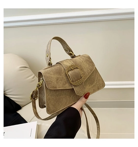 Detail shot of vintage brown leather handbag with retro metal buckle and textured finish