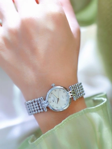 Detailed shot of women's quartz watch with silver chain strap and rhinestone markers