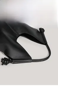 Close-up of the knot handle detail on a black minimalist leather tote shoulder bag