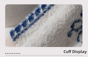 Macro detail of soft ivory knit sleeve with blue jacquard pattern and fuzzy texture