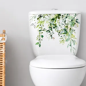 Close-up of green hanging leaves wall decal applied to a white ceramic toilet tank surface