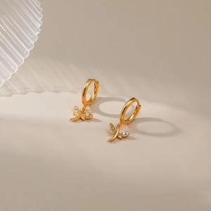Close-up of gold dragonfly hoop earrings with tiny white zircon stones on wings