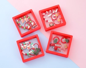 Close-up of children's Christmas jewelry sets with elk and snowflakes in red PE film boxes