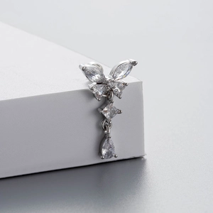 Silver butterfly drop earring with sparkling zircon stones on a white stand