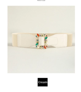 Close-up of a wide cream elastic belt featuring a luxury colorful gemstone buckle