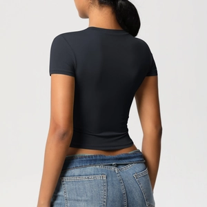 Slim fit black cropped athletic t-shirt for yoga paired with blue washed denim jeans