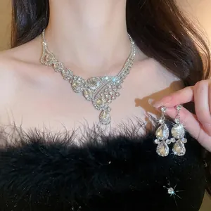 Elegant silver teardrop rhinestone necklace and earring bridal jewelry set on a model