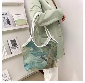 Artistic oil painting canvas tote bag shown worn on shoulder by model in mint blazer