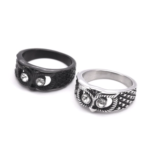 Close-up of black and silver owl rings with crystal eyes and engraved feather textures