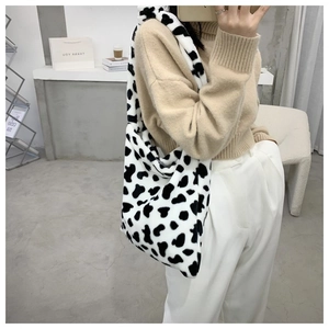 Detailed view of the soft cow print faux fur texture on a large capacity shoulder bag