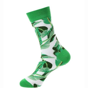 Detailed close-up of green and white cotton socks featuring tropical leaf patterns