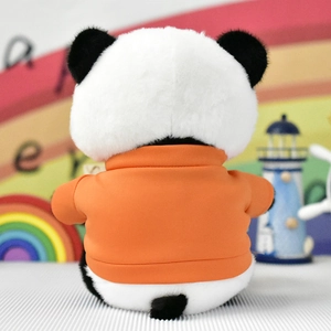 Vista posteriore di un simpatico panda di peluche con felpa arancione in un ambiente arcobaleno.