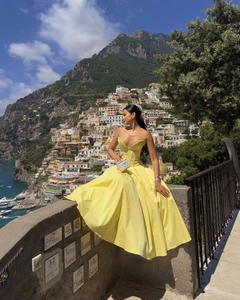 Detail of a bright yellow strapless satin dress with a corset bodice and voluminous skirt