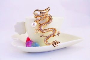 Close-up of golden dragon keychain with colorful rhinestones and a white pearl detail