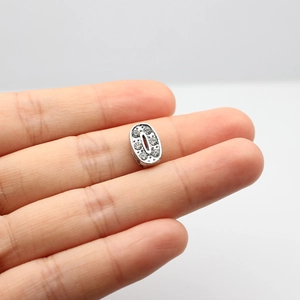 Macro view of silver rhinestone number zero charm for DIY bracelets and keychains