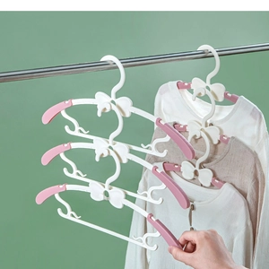 Pink and white telescopic kids hangers with bow design shown in a space-saving vertical stack
