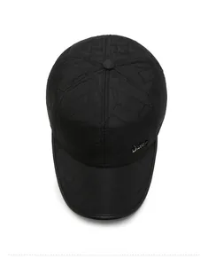 Close-up of black quilted baseball cap with geometric stitching and JEANS metal logo
