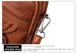 Detail showing the brown lychee leather texture and detachable metal strap buckle