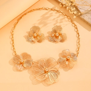 Elegant gold hollow flower necklace and earrings jewelry set on natural stone background