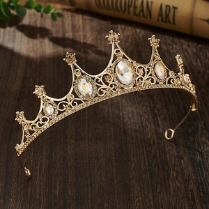 Detailed close-up of golden vintage crown with champagne gemstones on a dark wood surface