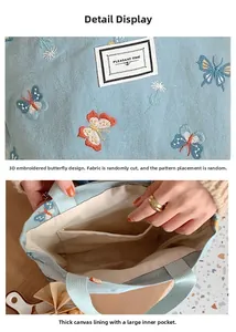 Détail du sac en toile bleue avec broderie papillon 3D et grande poche intérieure