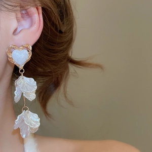 Close-up of heart shell petal tassel earrings showing golden edges and elegant long drop design