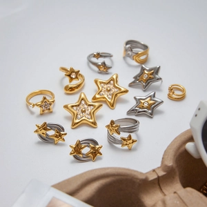 Star-shaped jewelry set including gold and silver rings and earrings with zircon stones