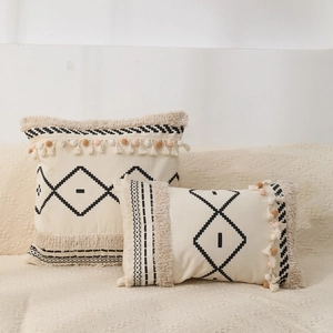 Bohemian tufted pillow covers with black diamond embroidery and fringe on a sofa