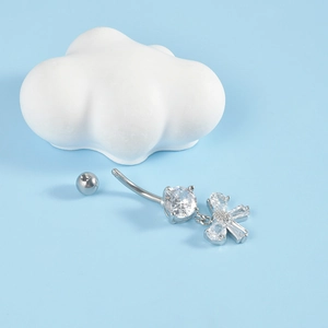 Silver butterfly belly button ring with sparkling zircon heart on light blue background