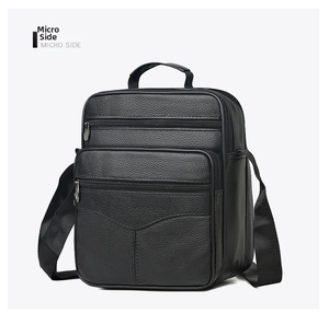 Macro side view of black pebble grain leather messenger bag showing multi-compartment texture
