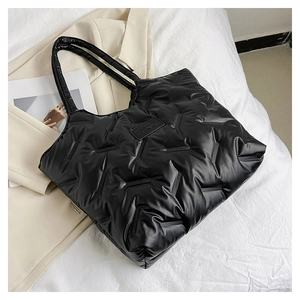 Detail der schwarzen gesteppten Puffer-Einkaufstasche mit Fashion Bags Label auf Leinen