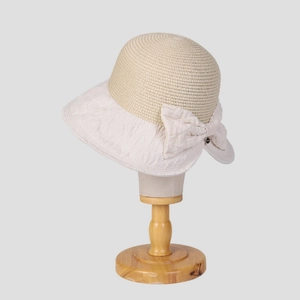 Minimalist straw bucket hat with bow detail on wooden stand for summer sun protection
