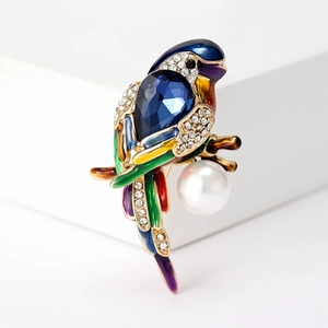 Chic parrot brooch with crystals, blue gemstone, and white pearl in a golden finish