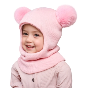 Detailed knit texture of pink kids winter balaclava with soft double faux fur pompoms