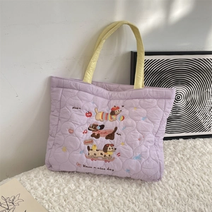 Détail de la broderie chiots sur le sac matelassé violet avec poignées jaunes